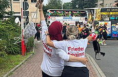 2 jubelnde Frauen sind von hinten zu sehen.