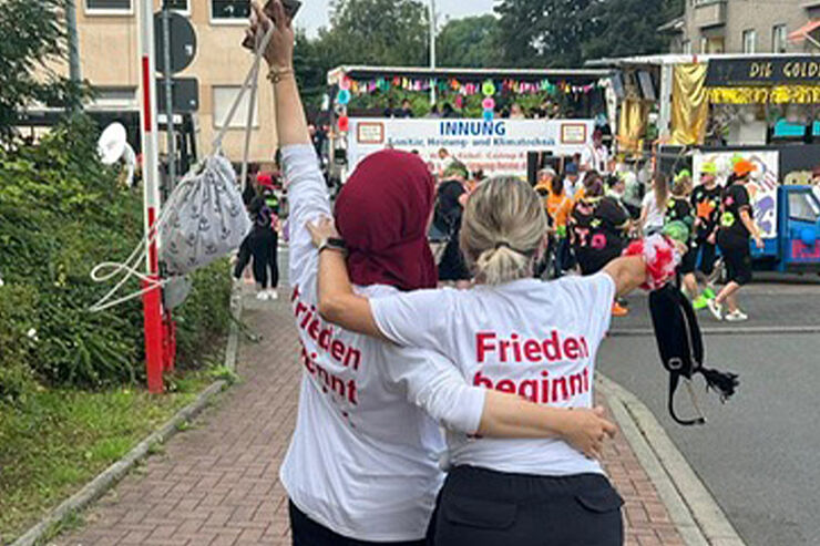 2 jubelnde Frauen sind von hinten zu sehen.