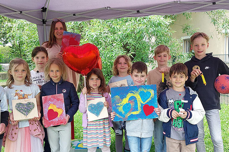 Gruppe Frau und Kinder mit Kunstwerken mit Herzmotiv