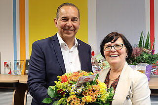 Ein Mann überreicht einer Frau Blumen.